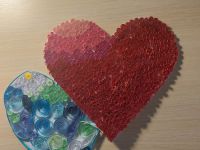 Siódme zdjęcie przedstawia serce wykonane przez zwyciężczynię pierwszego miejsca  w kat. dzieci do lat 14. Dwa połączone serca jedno czerwone drugie niebiesko zielono białe zostały wykonane metodą kulingową polegającą na zwijaniu wąskich pasków kolorowego papieru.